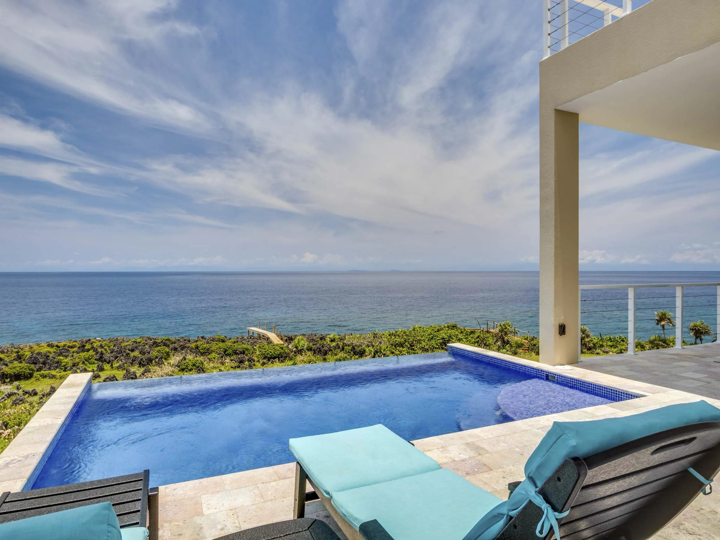Pool deck and covered terrace of a completed West Bay home.